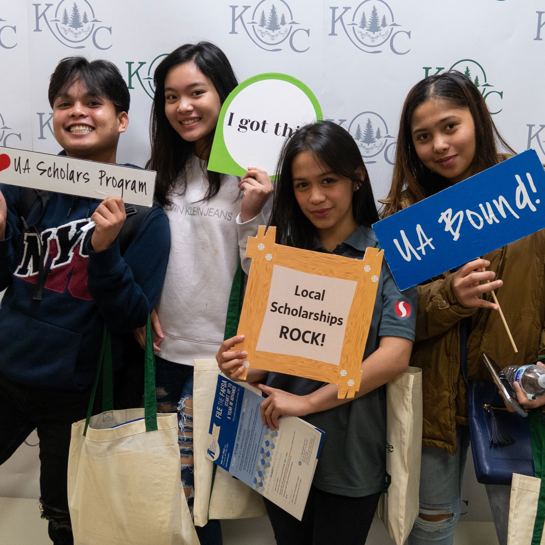 students holding up scholarship selfie signs